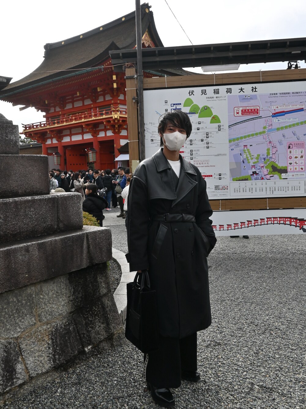 ブラック系のトレンチコート、ブラック系のトートバッグ、ブラック系のその他パンツを着用したメンズの冬コーディネートの2枚目の写真