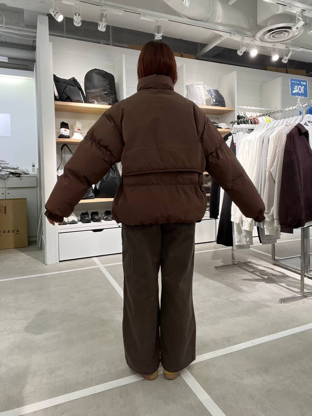 ブラウン系のダウンジャケット/コート、ブラウン系のデニムパンツを着用したメンズの冬コーディネートの4枚目の写真