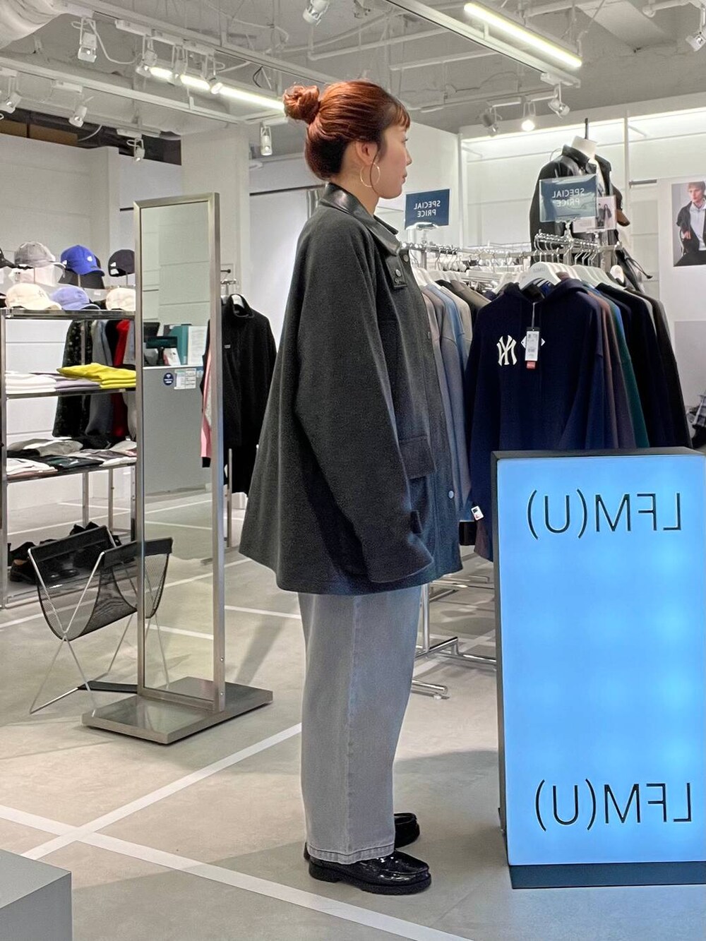 グレー系のブルゾン、ブラック系のデニムパンツ、パープル系のニット/セーターを着用したメンズの秋コーディネートの3枚目の写真