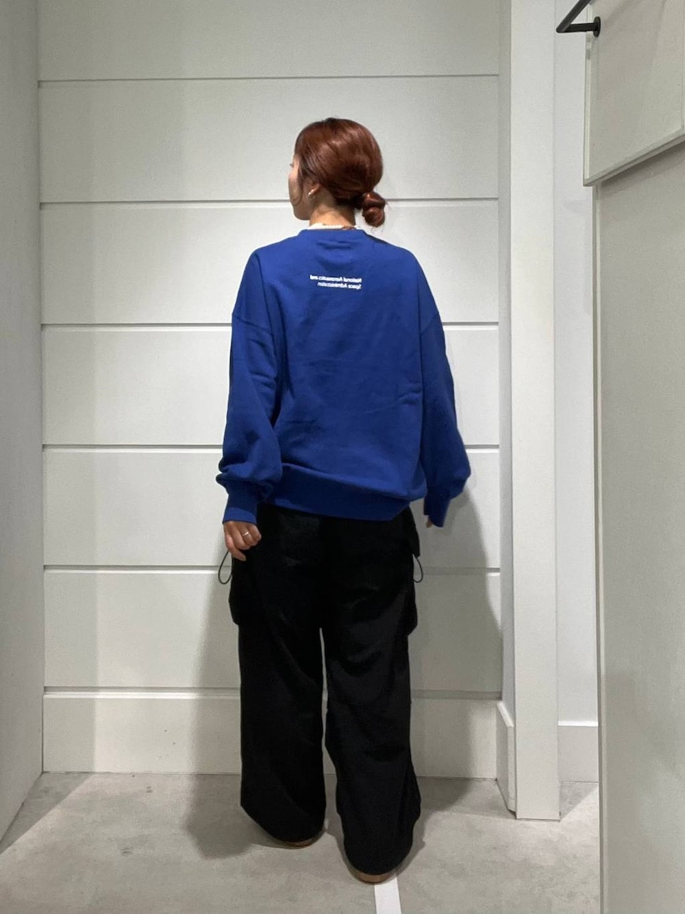 ブラック系のカーゴパンツ、ブルー系のスウェット、ホワイト系のネックレスを着用したメンズの秋コーディネートの3枚目の写真