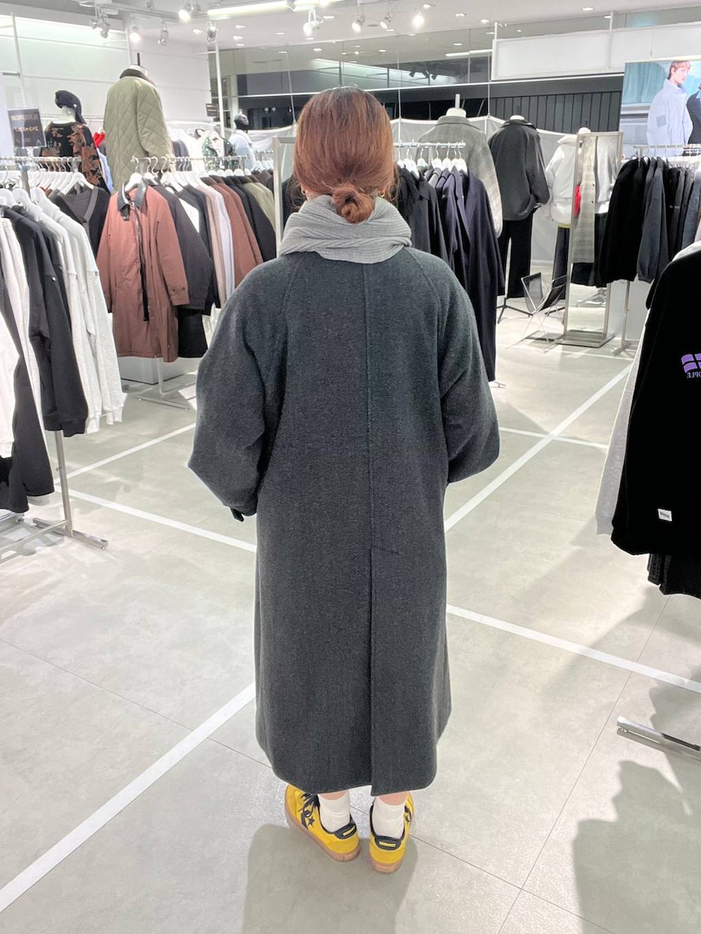 グレー系のチェスターコート、グレー系のマフラーを着用したメンズの秋コーディネートの3枚目の写真