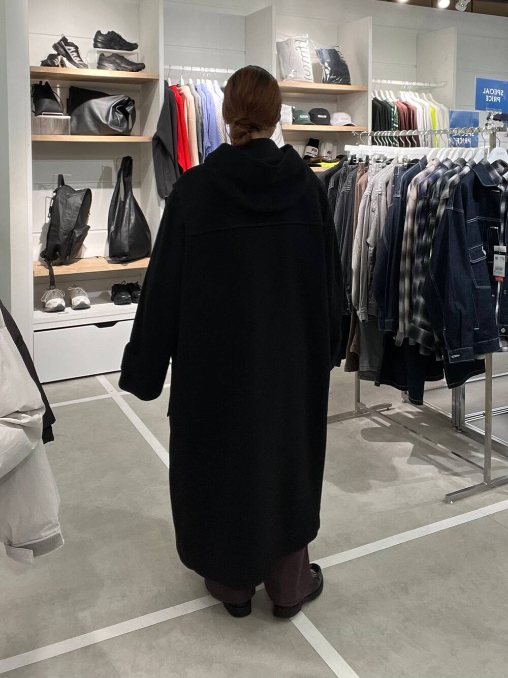ブラック系のダッフルコート、ブラウン系のデニムパンツを着用したメンズの秋コーディネートの4枚目の写真