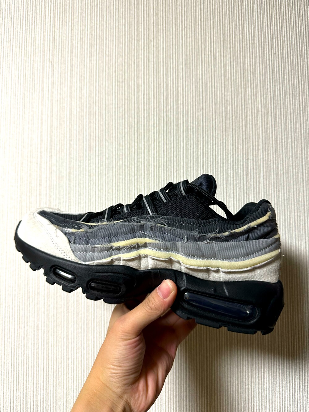 ホワイト系のスニーカー、ブラック系のカーゴパンツ、グレー系のパーカーを着用したメンズの春コーディネートの2枚目の写真