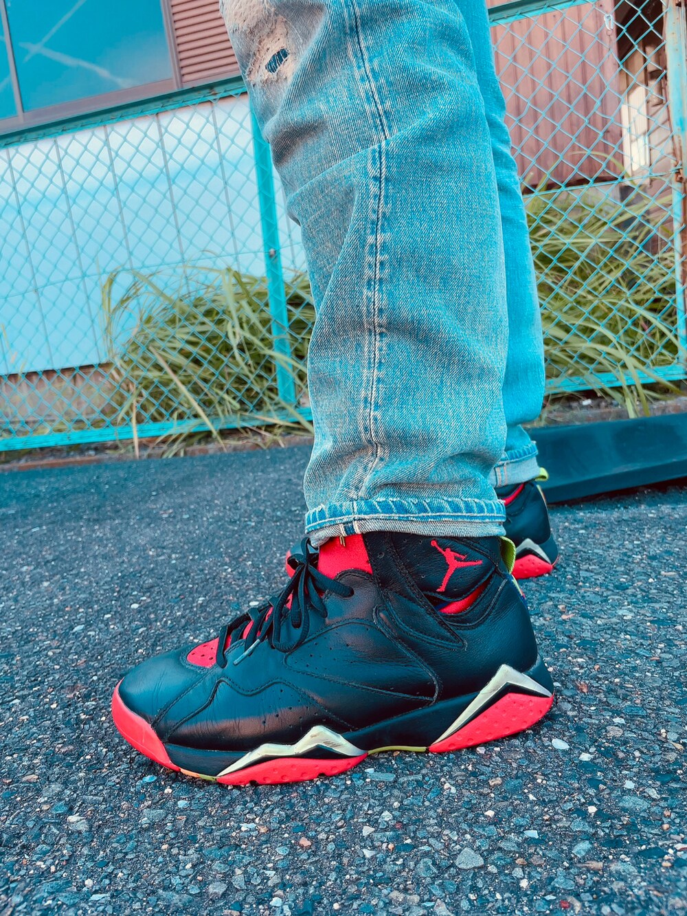 ブラック系のスニーカー、ブルー系のデニムパンツ、ホワイト系のTシャツ/カットソーを着用したメンズの秋コーディネートの2枚目の写真