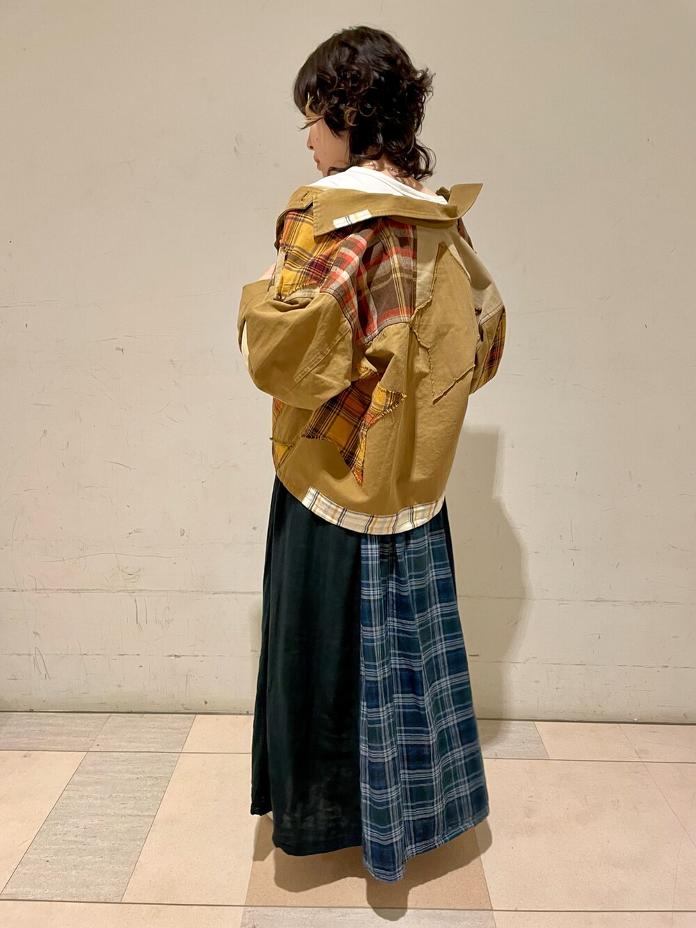 ホワイト系のTシャツ/カットソー、ベージュ系のその他アウター、グリーン系のスカートを着用したレディースの秋コーディネートの3枚目の写真