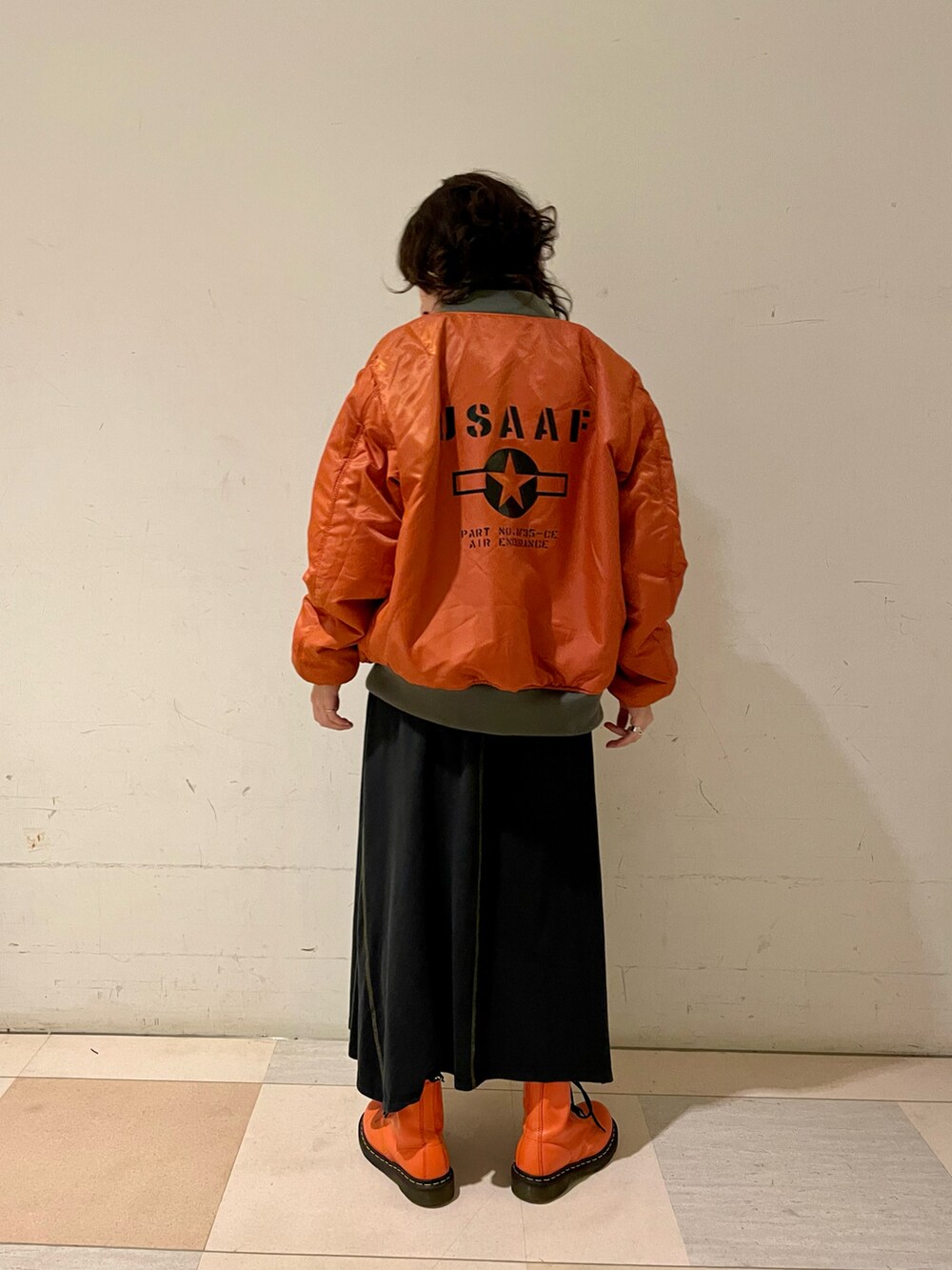 グリーン系のMA-1、グリーン系のTシャツ/カットソー、ブラック系のスカートを着用したレディースの秋コーディネートの2枚目の写真