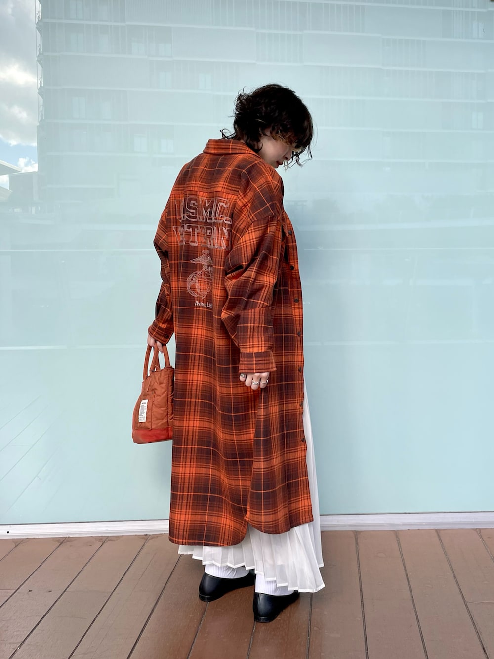 オレンジ系のシャツワンピース、レッド系のバッグ、その他のスカートを着用したレディースの秋コーディネートの2枚目の写真