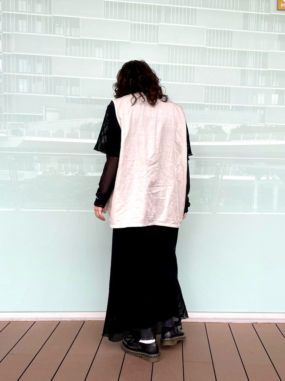 ブラック系のワンピース、ホワイト系のベストを着用したレディースの春コーディネートの2枚目の写真