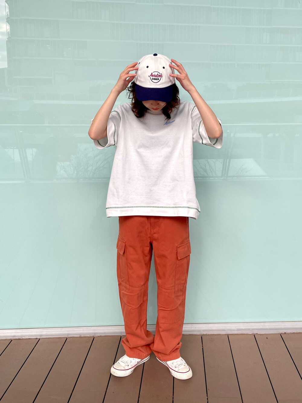 ホワイト系のTシャツ/カットソー、レッド系のカーゴパンツ、ホワイト系のキャップを着用したレディースの春コーディネートの2枚目の写真