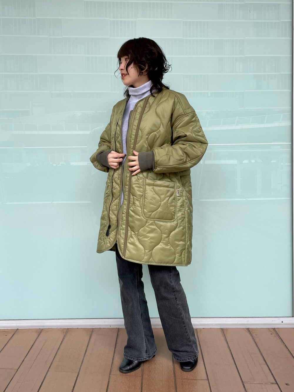 グレー系のスウェット、グリーン系のジャケット/アウター、ブラック系のデニムパンツを着用したレディースの秋コーディネートの2枚目の写真