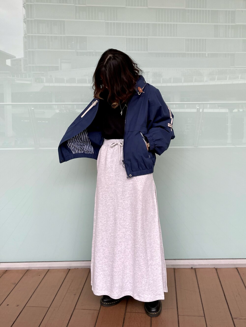 ブルー系のブルゾン、グレー系のスカート、ブラック系のTシャツ/カットソーを着用したレディースの冬コーディネートの2枚目の写真