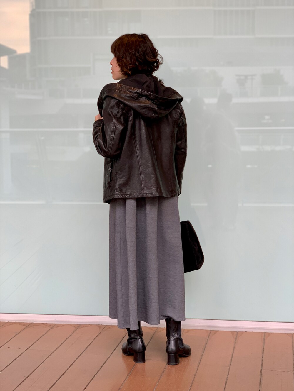 ブラック系のライダースジャケット、グレー系のワンピース/ドレス、ブラック系のトートバッグを着用したレディースの秋コーディネートの2枚目の写真