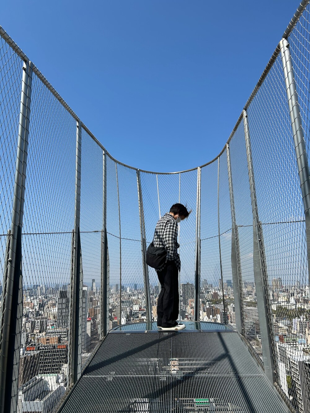 ブラック系のシャツ/ブラウス、ブラック系のスラックス、ブラック系のスニーカーを着用したレディースの春コーディネートの2枚目の写真