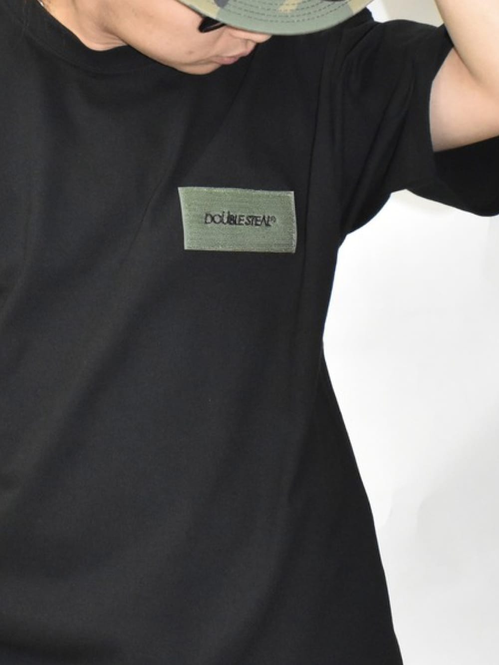 ブラック系のスニーカー、ブルー系のパンツ、ホワイト系のTシャツ/カットソーを着用したメンズの春コーディネートの2枚目の写真