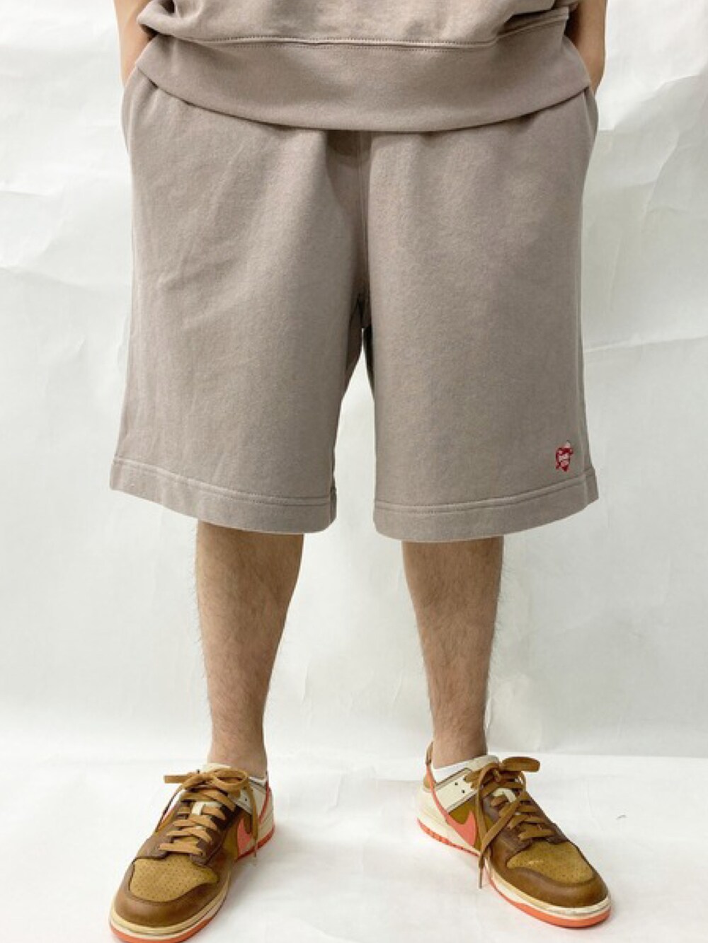 ブラック系のスニーカー、ベージュ系のスウェットパンツ、グリーン系のTシャツ/カットソーを着用したメンズの秋コーディネートの5枚目の写真