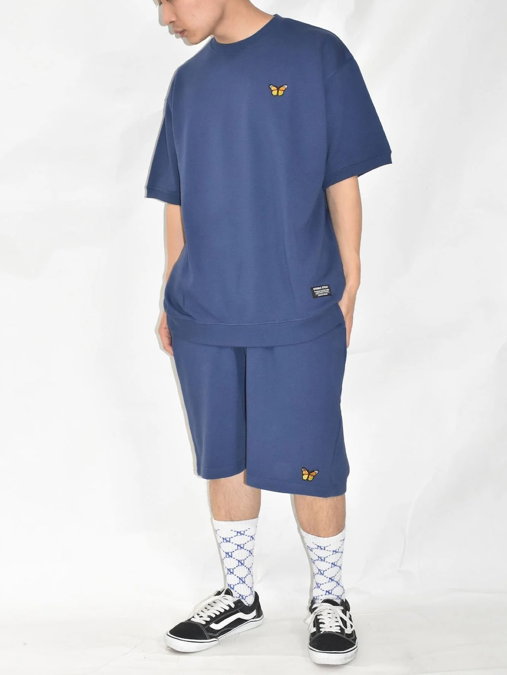 ブラック系のスニーカー、ブルー系のスウェットパンツ、グリーン系のTシャツ/カットソーを着用したメンズの夏コーディネートの4枚目の写真