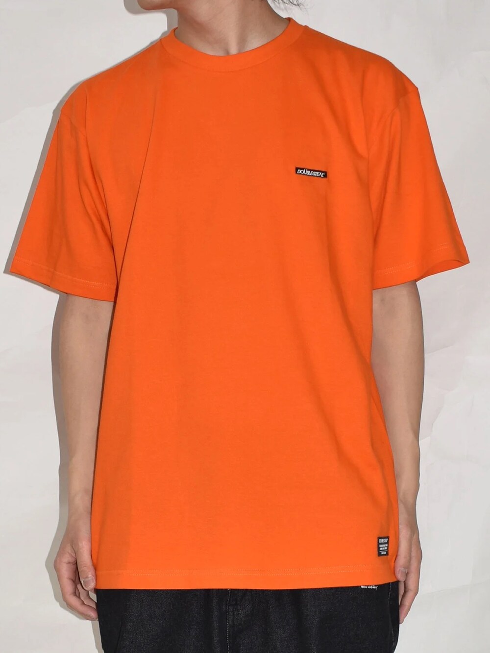 ブラック系のスニーカー、グレー系のその他パンツ、オレンジ系のTシャツ/カットソーを着用したメンズの春コーディネートの3枚目の写真