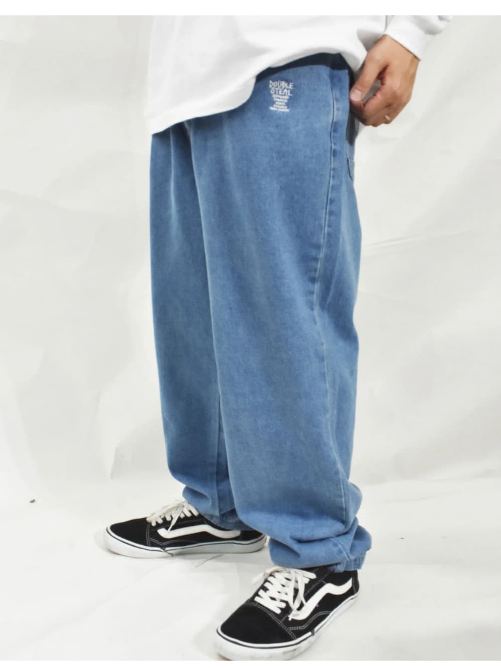 ブラック系のスニーカー、ブルー系のデニムパンツ、グレー系のスウェットを着用したメンズの冬コーディネートの3枚目の写真