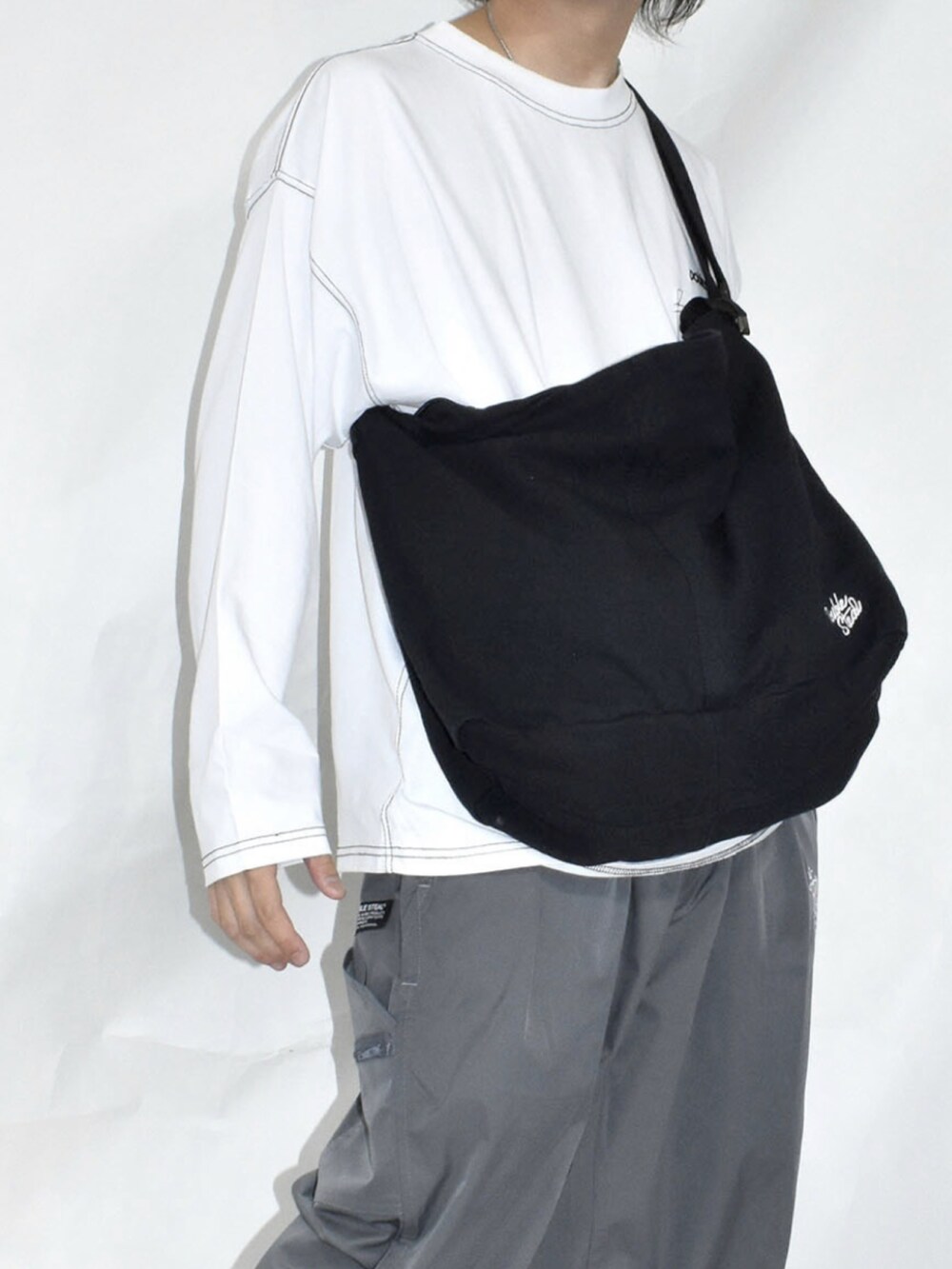 ブラウン系のスニーカー、ブルー系のデニムパンツ、ブラック系のトートバッグを着用したメンズの冬コーディネートの4枚目の写真