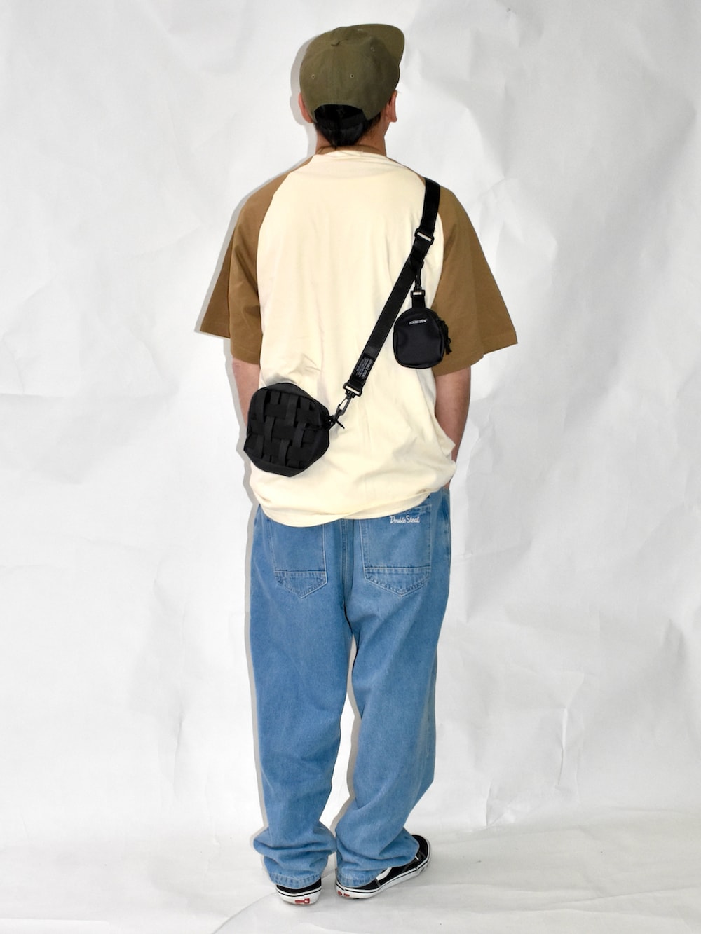 ブラック系のスニーカー、ブルー系のデニムパンツ、ブラウン系のTシャツ/カットソーを着用したメンズの夏コーディネートの2枚目の写真