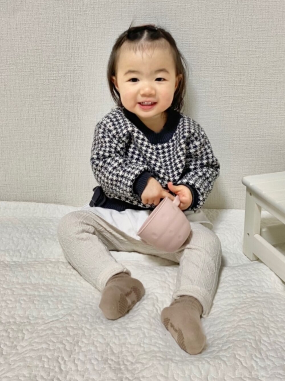 ブラック系のチュニック、ホワイト系のレギンス/スパッツを着用したキッズの冬コーディネートの2枚目の写真