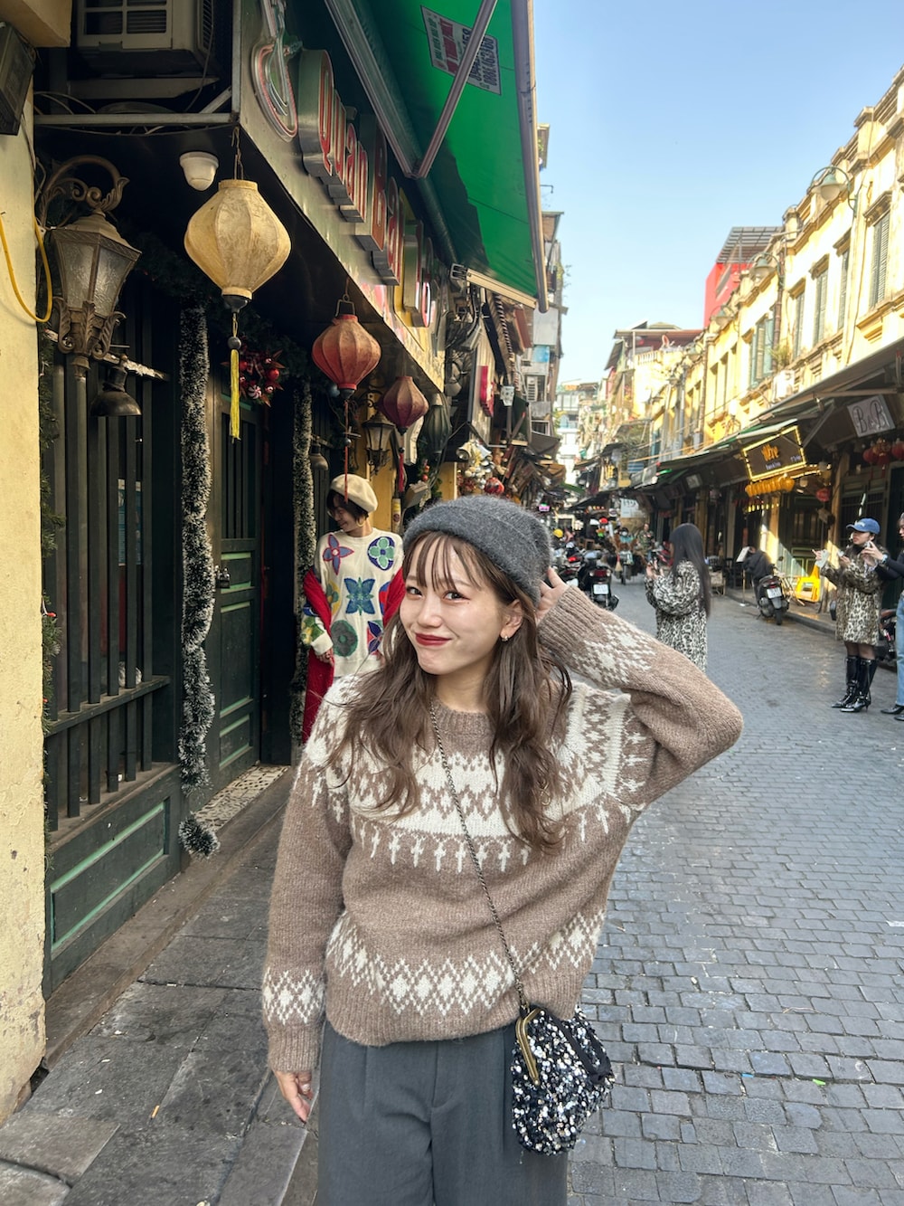 ブラウン系のニット/セーター、グレー系のスラックス、ブラウン系のブーツを着用したレディースの冬コーディネートの2枚目の写真