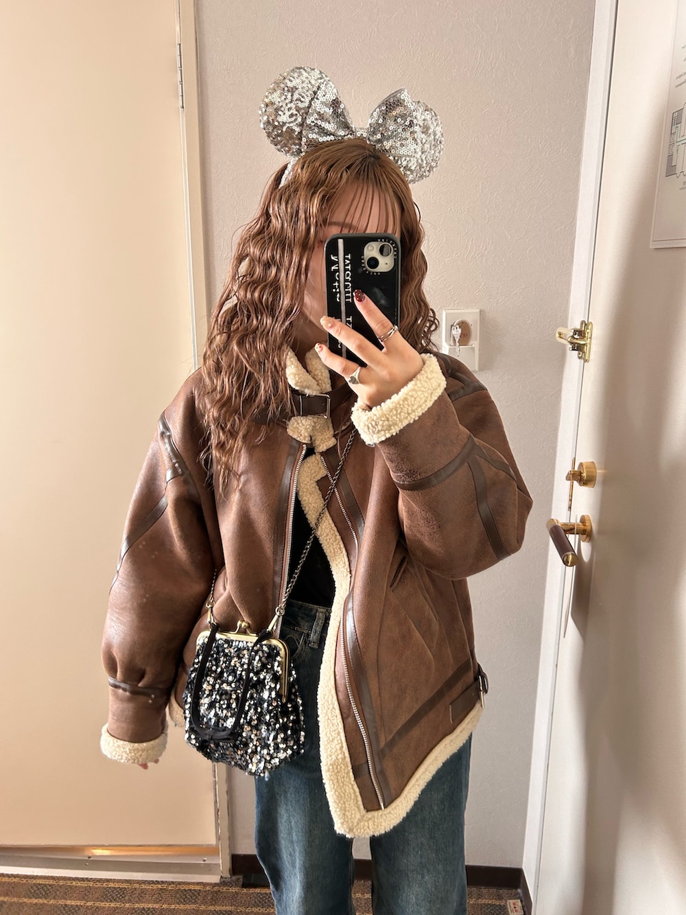 ブラウン系のその他アウター、ブルー系のデニムパンツ、ブラウン系のブーツを着用したレディースの冬コーディネートの2枚目の写真