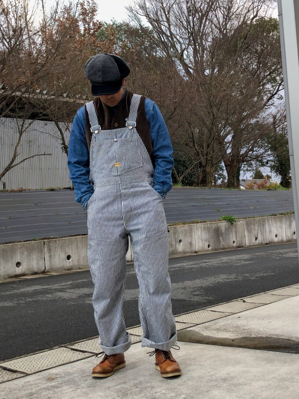 ブラウン系のブーツ、ブルー系のサロペット/オーバーオール、グリーン系のモッズコートを着用したメンズの冬コーディネートの3枚目の写真