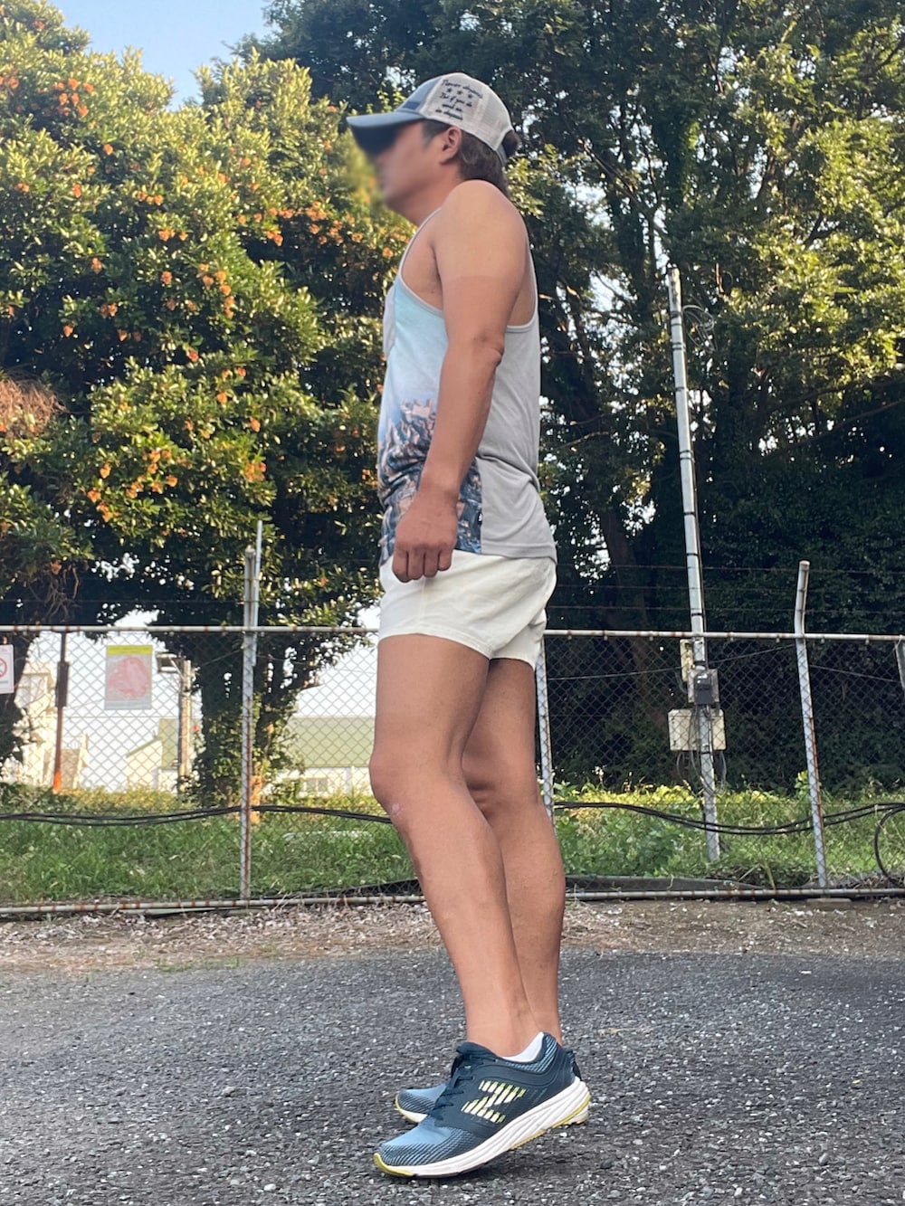 ブルー系のスニーカー、ブルー系のタンクトップ、ホワイト系のパンツを着用したメンズの夏コーディネートの2枚目の写真