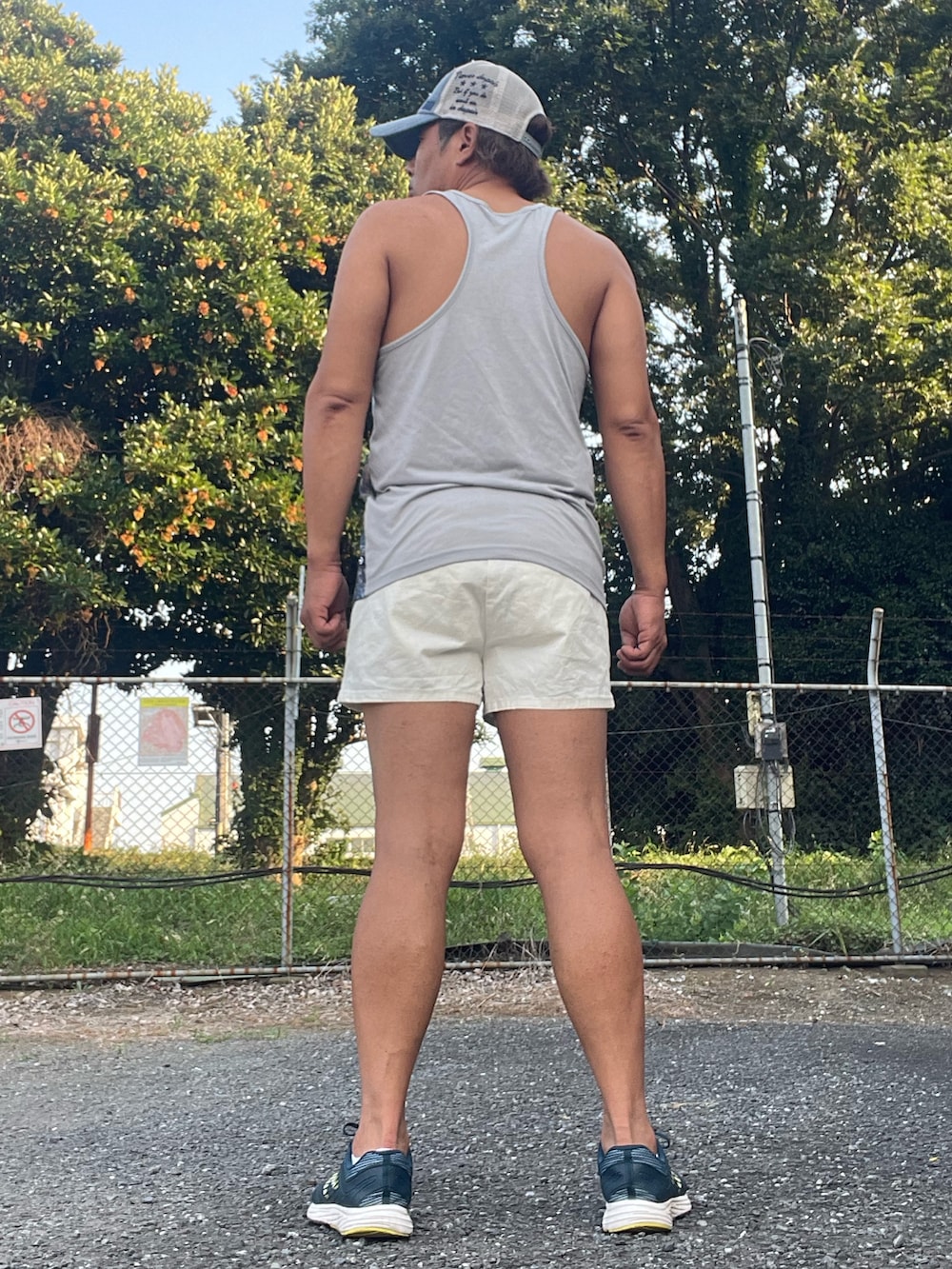 ブルー系のスニーカー、ブルー系のタンクトップ、ホワイト系のパンツを着用したメンズの夏コーディネートの3枚目の写真