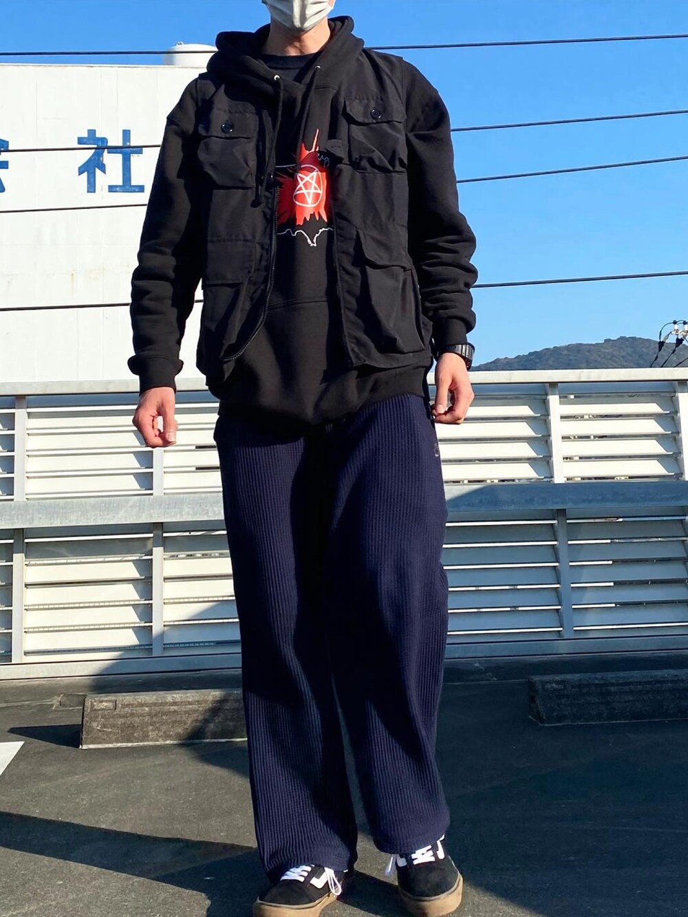 ブラック系のベスト、ブルー系のその他パンツ、ブラック系のスニーカーを着用したメンズの秋コーディネートの2枚目の写真