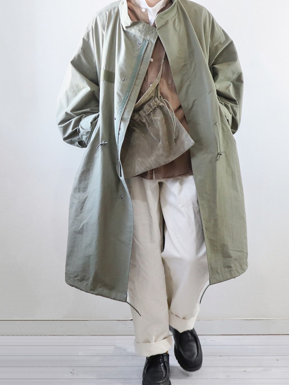 グリーン系のモッズコート、ブラウン系のシャツ/ブラウス、グリーン系のショルダーバッグを着用したメンズの冬コーディネートの2枚目の写真