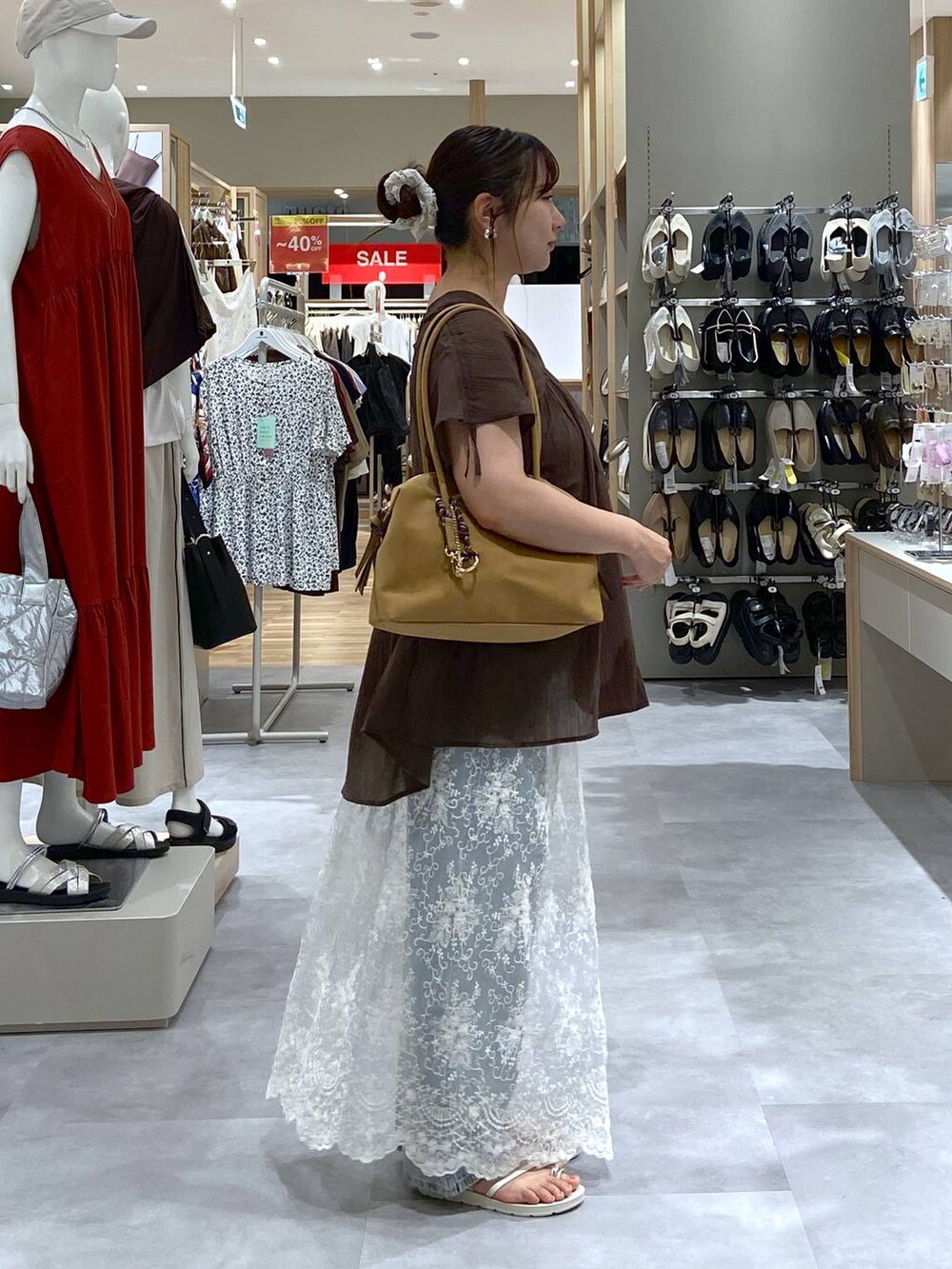 ブルー系のデニムパンツ、ブラウン系のシャツ/ブラウス、ベージュ系のサンダルを着用したレディースの夏コーディネートの4枚目の写真