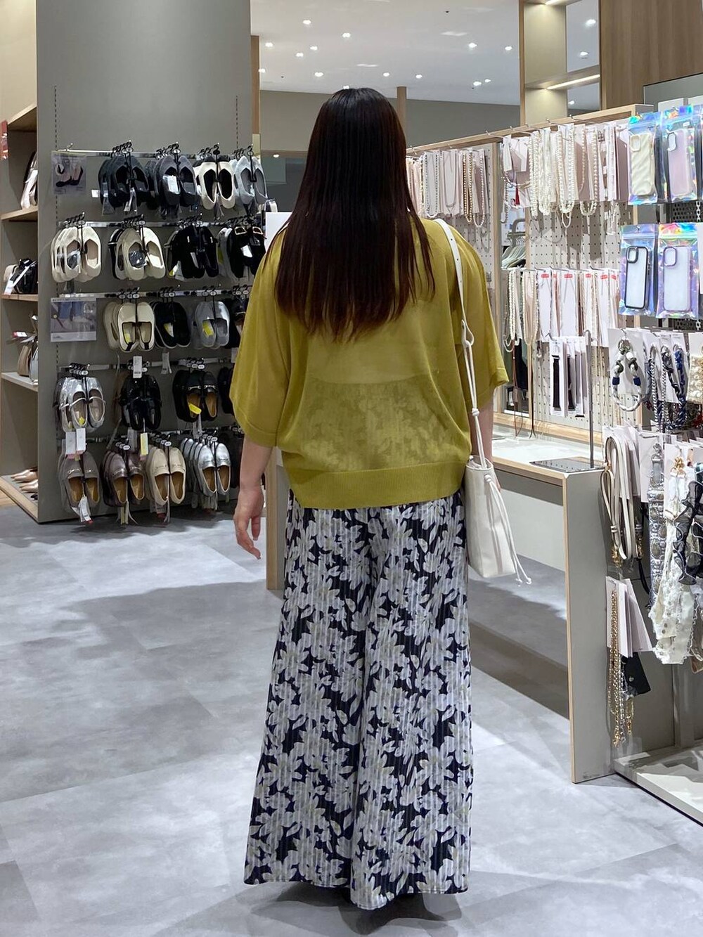 ホワイト系のショルダーバッグ、ブラック系のサンダル、グリーン系のニット/セーターを着用したレディースの夏コーディネートの3枚目の写真