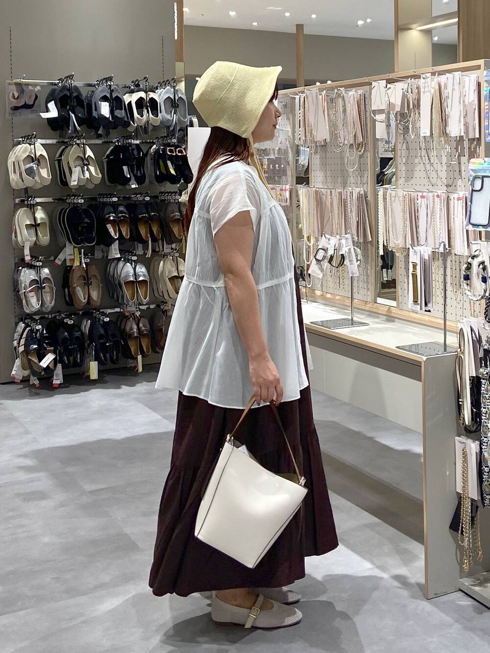 ホワイト系のショルダーバッグ、ホワイト系のパンプス、ホワイト系のシャツ/ブラウスを着用したレディースの夏コーディネートの4枚目の写真