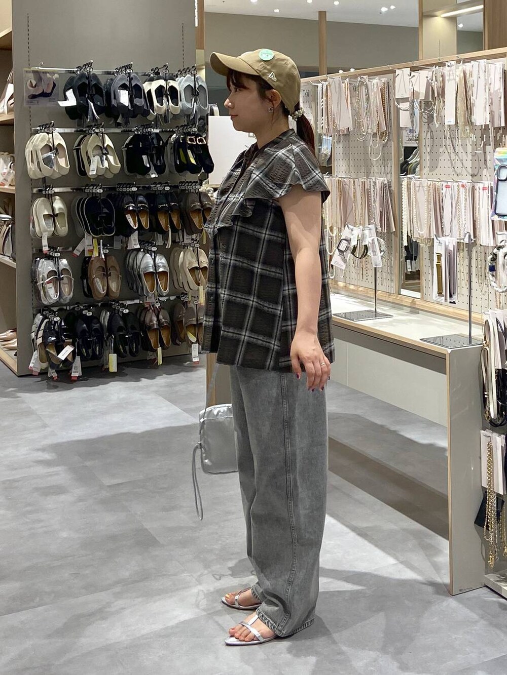 グレー系のデニムパンツ、シルバー系のショルダーバッグ、シルバー系のサンダルを着用したレディースの夏コーディネートの2枚目の写真