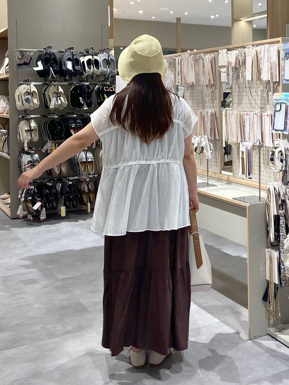 ホワイト系のショルダーバッグ、ホワイト系のパンプス、ホワイト系のシャツ/ブラウスを着用したレディースの夏コーディネートの3枚目の写真