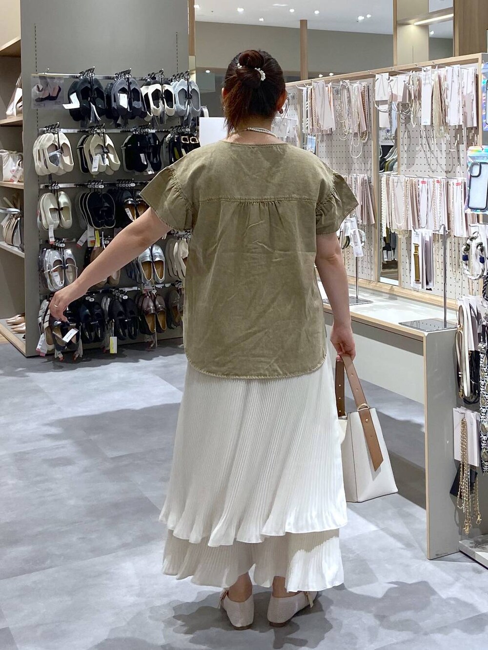 ホワイト系のショルダーバッグ、ホワイト系のパンプス、ホワイト系のスカートを着用したレディースの夏コーディネートの3枚目の写真