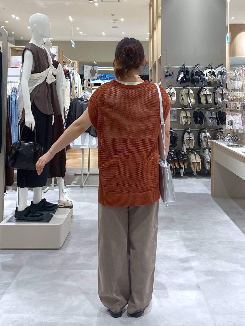 ブラウン系のTシャツ/カットソー、シルバー系のショルダーバッグ、ブラウン系のデニムパンツを着用したレディースの夏コーディネートの2枚目の写真