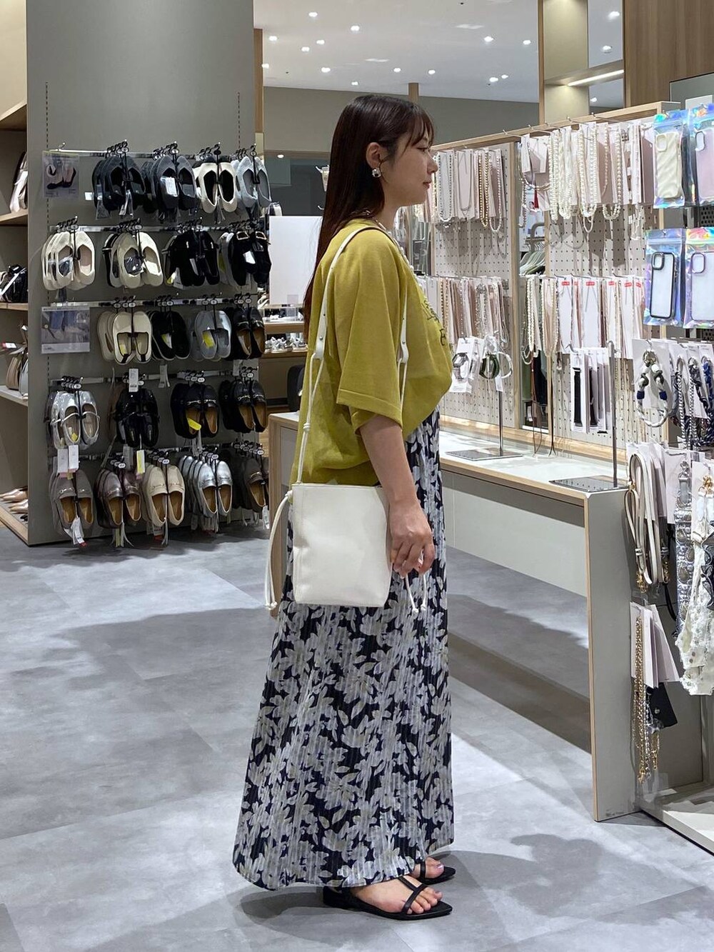 ホワイト系のショルダーバッグ、ブラック系のサンダル、グリーン系のニット/セーターを着用したレディースの夏コーディネートの4枚目の写真