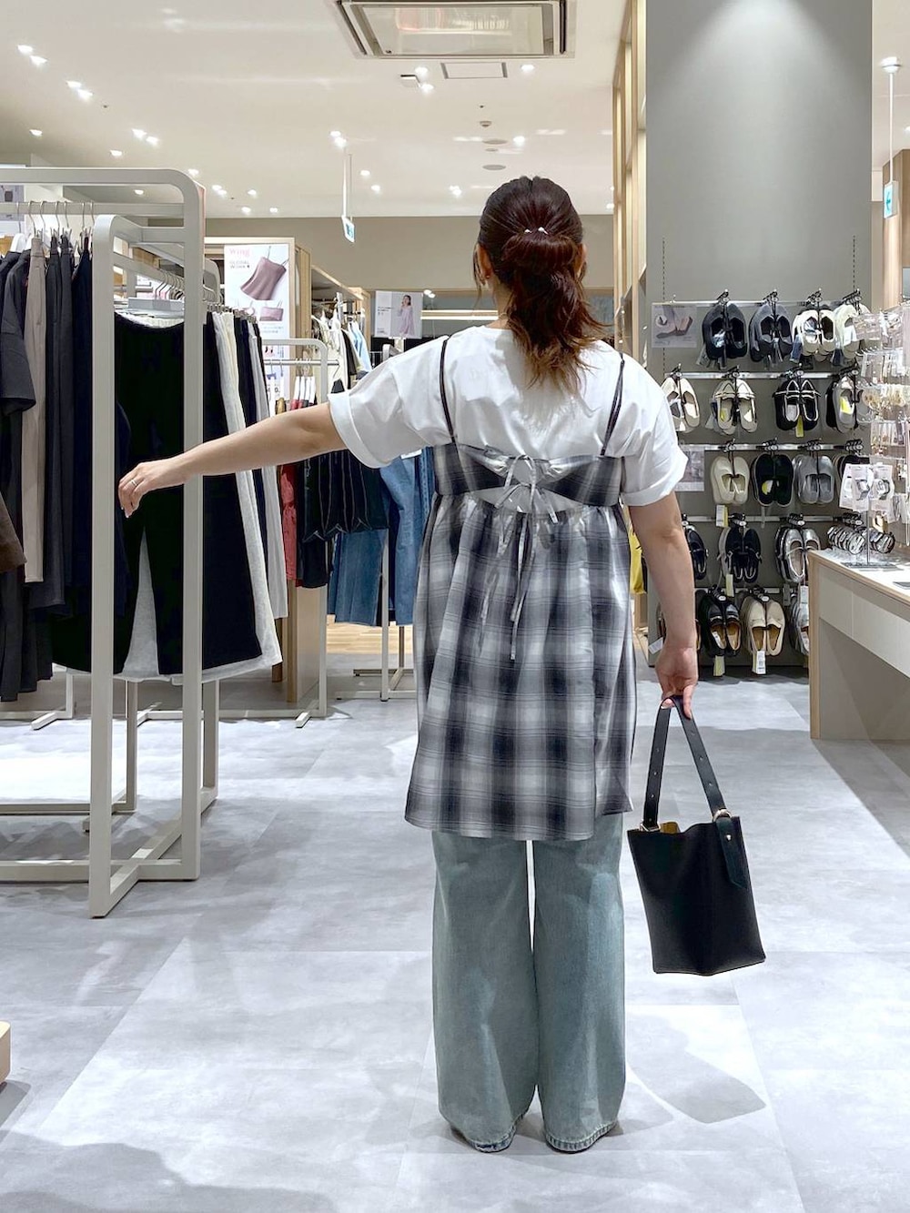 ホワイト系のTシャツ/カットソー、ブラック系のショルダーバッグ、グレー系のパンプスを着用したレディースの夏コーディネートの3枚目の写真