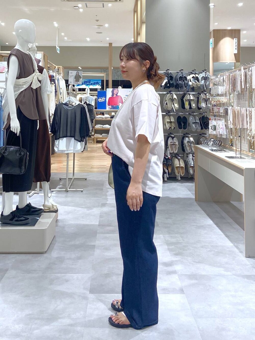 ホワイト系のショルダーバッグ、ピンク系のTシャツ/カットソー、ブルー系のデニムパンツを着用したレディースの夏コーディネートの2枚目の写真