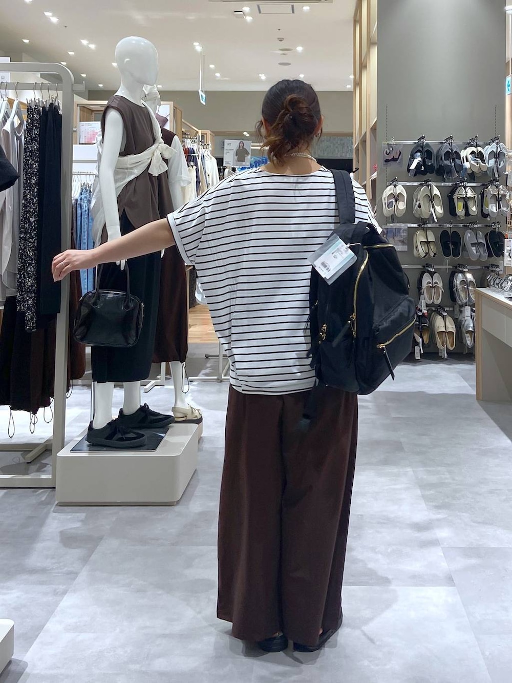 ブラック系のバックパック/リュック、ブラック系のサンダル、ホワイト系のTシャツ/カットソーを着用したレディースの夏コーディネートの3枚目の写真