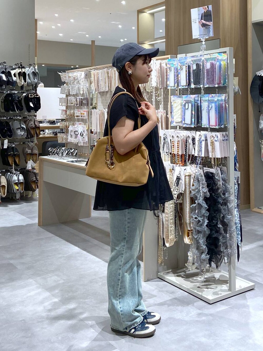 ブラック系のシャツ/ブラウス、ベージュ系のボストンバッグ、ブルー系のデニムパンツを着用したレディースの夏コーディネートの4枚目の写真