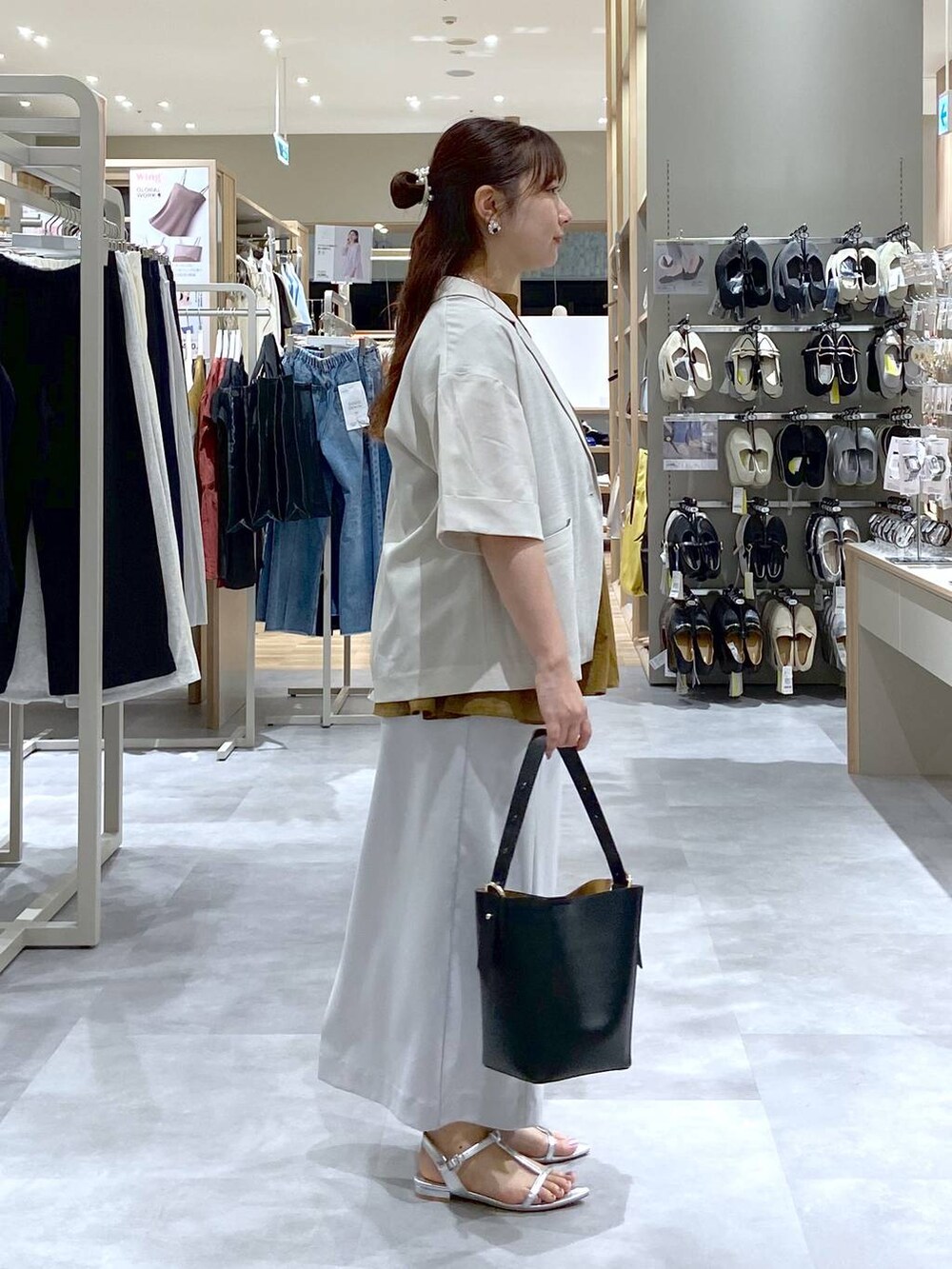 ブラック系のショルダーバッグ、シルバー系のサンダル、グレー系のスカートを着用したレディースの夏コーディネートの5枚目の写真