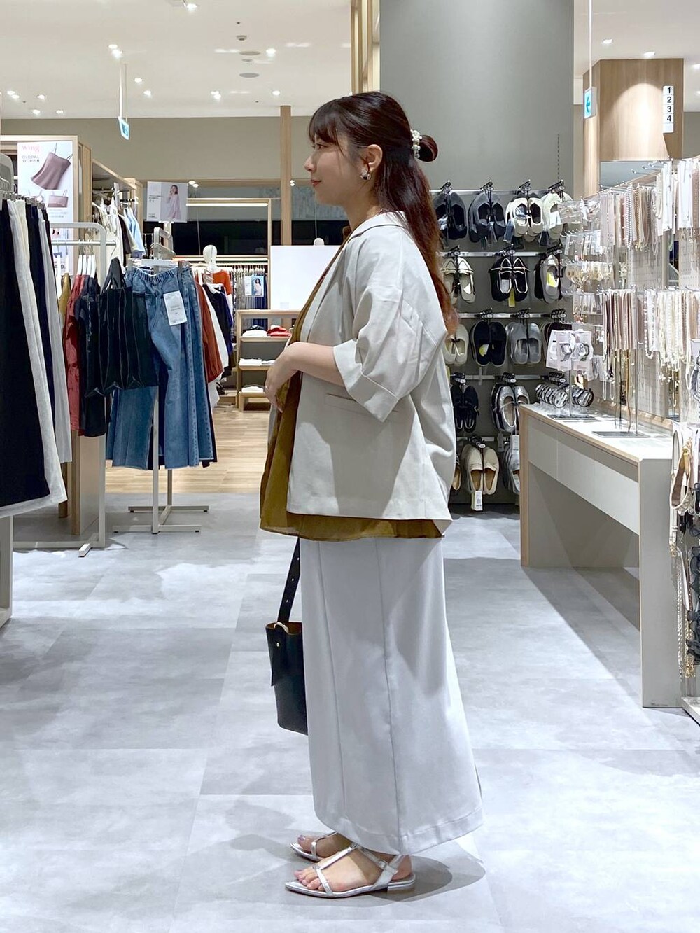 ブラック系のショルダーバッグ、シルバー系のサンダル、グレー系のスカートを着用したレディースの夏コーディネートの3枚目の写真