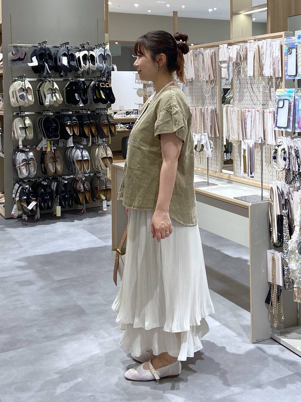 ホワイト系のショルダーバッグ、ホワイト系のパンプス、ホワイト系のスカートを着用したレディースの夏コーディネートの2枚目の写真