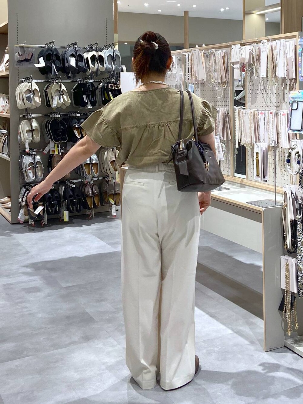 ホワイト系のその他パンツ、ブラウン系のボストンバッグ、ベージュ系のシャツ/ブラウスを着用したレディースの夏コーディネートの3枚目の写真