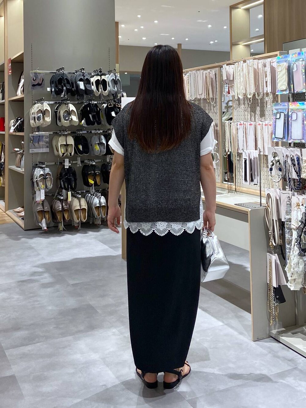 シルバー系のショルダーバッグ、ブラック系のサンダル、ホワイト系のTシャツ/カットソーを着用したレディースの夏コーディネートの3枚目の写真