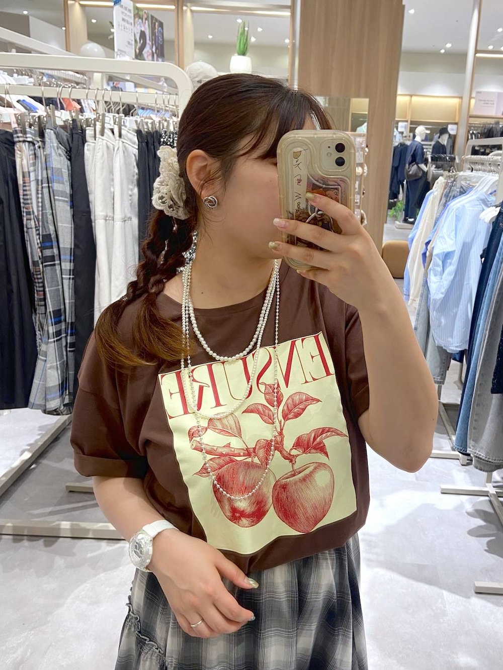 ブラック系のスカート、ブルー系のシュシュ、シルバー系のネックレスを着用したレディースの夏コーディネートの2枚目の写真